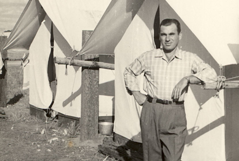 1956. An Italian migrant in his best attire in front of his camp tent in Western Australia.
